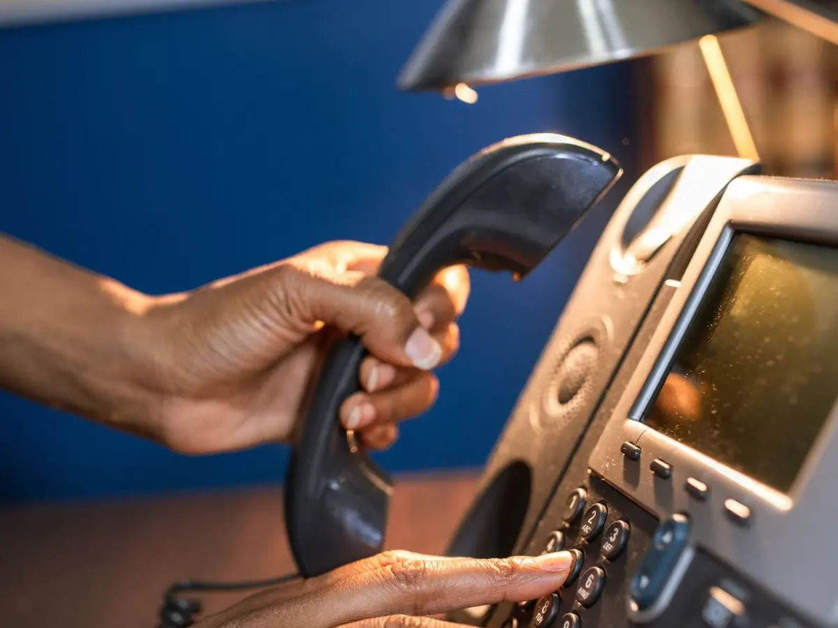 Person dialing a phone to call for water heater help