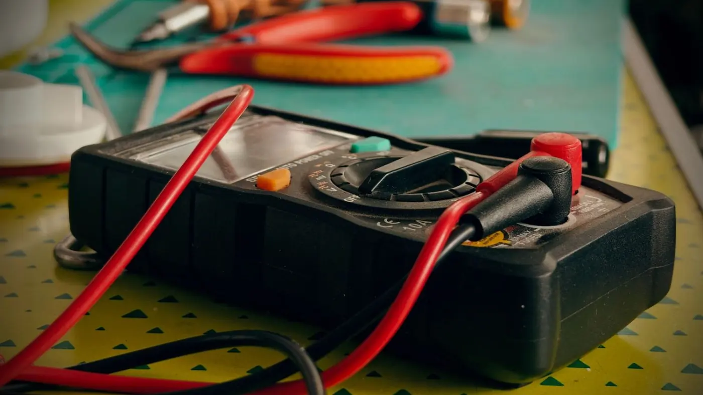 Multimeter and hand tools used to diagnose electric water heater faults