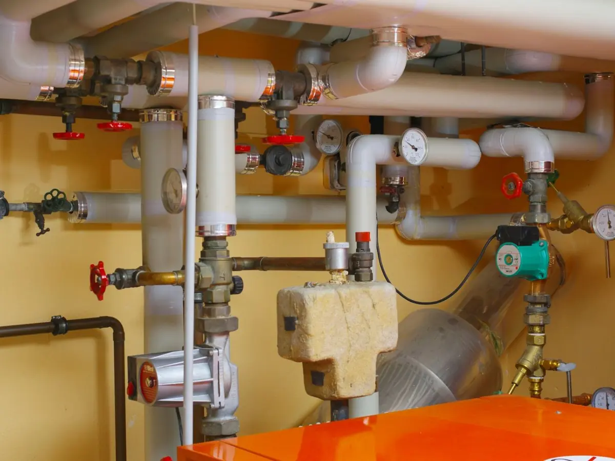 Gas and water lines with shutoff valves feeding a gas-fired heater