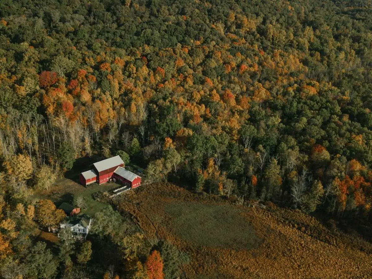 Red farmhouse among autumn woods in the Hudson Valley