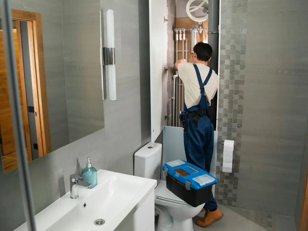 Plumber with a toolbox arriving to work in a home bathroom