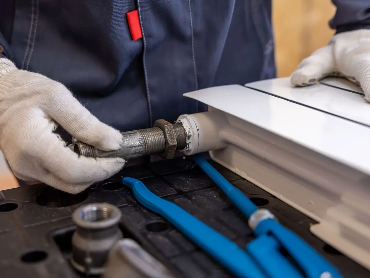 Plumber fitting a pipe connection with specialized tools