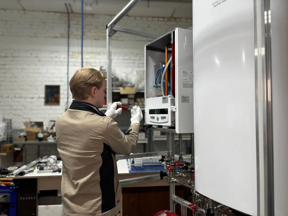 Technician servicing a wall-mounted tankless water heater