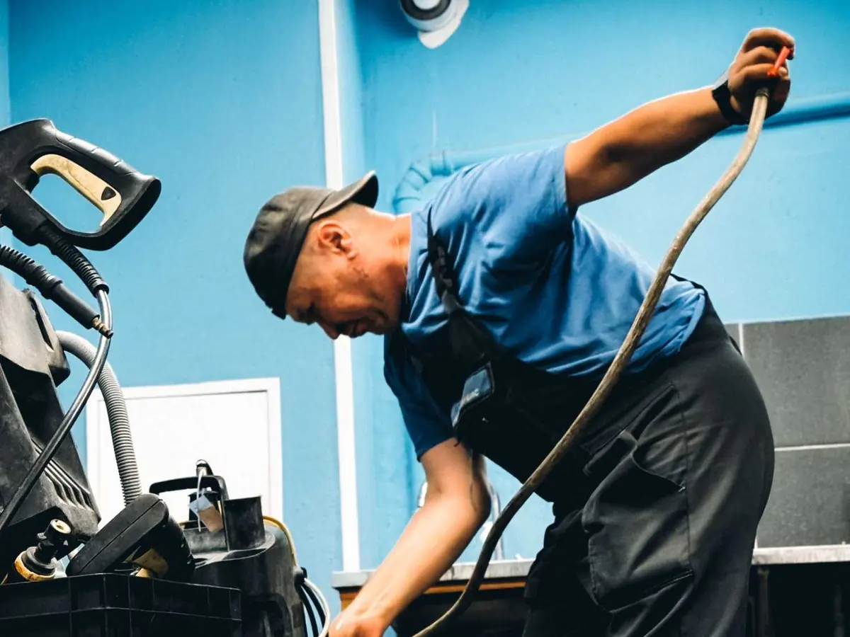 Technician in uniform working on household equipment